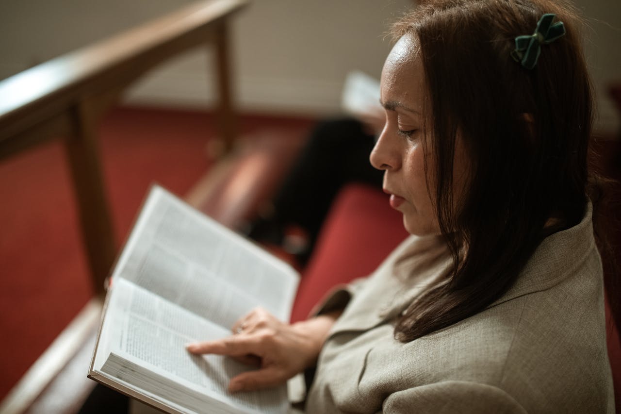 Close-Up Shot of a Woman Reading a Bible